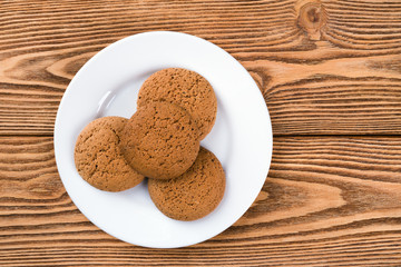 Oatmeal cookies on a plate on a wooden background 