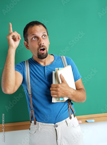 "Adult student holding books in his hand and finger ...