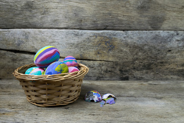Easter eggs in the basket on wooden