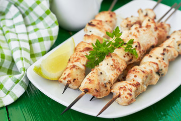 Chicken shish kebab on skewers with a lemon and parsley. horizontal