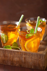 ice tea with lemon and mint on dark rustic background