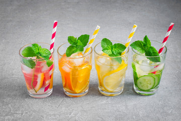 Refreshing summer drinks water with ice and lemon, orange, grape