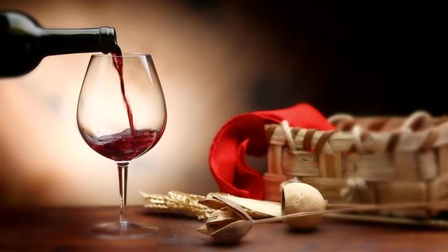 Loopable cinemagraph video. Pouring red wine into baloon wineglass.