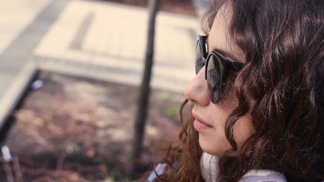 beautiful young woman in sunglasses looking ahead