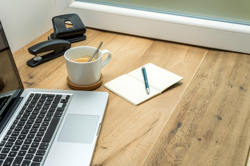 Wooden workspace with office supplies and coffee