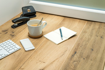 Wooden workspace with office supplies and coffee