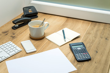 Wooden workspace with office supplies and coffee