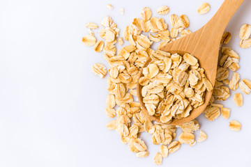 Rolled oats in a wooden spoon on white background
