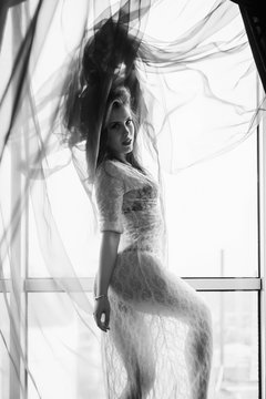 Black and white photography of sexy beautiful young lady in relaxing over window 