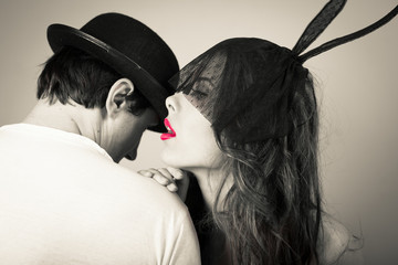 Black white of beautiful young lady wearing bunny ears whispering to man