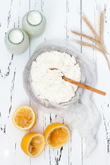 Soft homemade fresh ricotta cottage cheese made from milk, draining on muslin cloth. Tzfat cheese with wheat grains. Symbols of judaic holiday Shavuot.