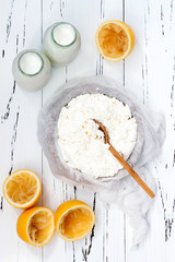 Soft homemade fresh ricotta cottage cheese made from milk, draining on muslin cloth. Tzfat cheese with wheat grains. Symbols of judaic holiday Shavuot.