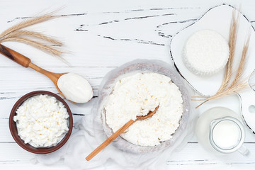 Soft homemade fresh ricotta cottage cheese made from milk, draining on muslin cloth. Tzfat cheese with wheat grains. Symbols of judaic holiday Shavuot. - obrazy, fototapety, plakaty