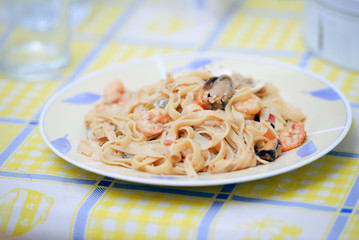 Closeup pasta with seafood and tomato sauce on table background
