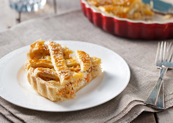 Cabbage pie on a white plate Grey textile background.