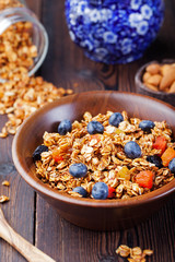 Healthy breakfast. Fresh granola, muesli with berries, honey and milk in a wooden bowl