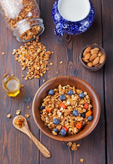 Healthy breakfast. Fresh granola, muesli with berries, honey and milk in a wooden bowl