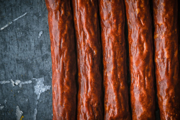 Several smoked sausages on a blue metallic background