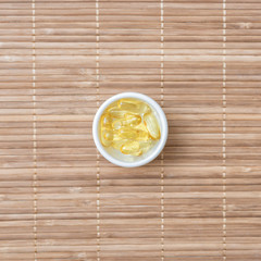 Cod liver oil omega 3 gel capsules on bamboo mat 