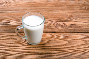 A cup of milk on a wooden background 