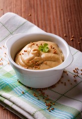 White bowl full of mustard on green towel