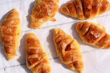 Fresh croissants on old wooden background, flat