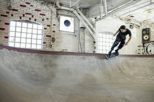 Young man skateboarding at basement skate park