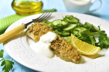 Cod baked with garlic bread crumbs garnished with cucumber salad