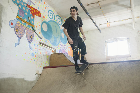 Young man skateboarding at basement skate park