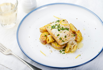 Roasted cod, codfish with baked potatoes and artichokes with lemon and herbs sauce