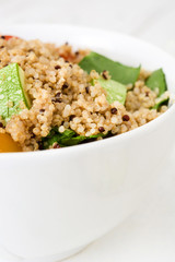 Quinoa salad in bowl on white wooden table
