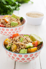 Quinoa salad in bowl on white wooden table

