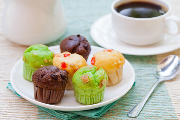 Assortment of muffins vanilla, chocolate, pandan on a white plate
