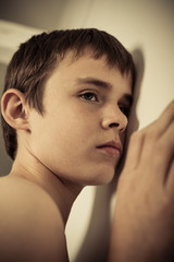 Young Teen Boy with Ear Pressed to Wall