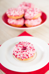 Donuts mit pinker Glasur und weissen und roten Streuseln