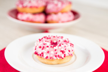 Donuts mit pinker Glasur und weissen und roten Streuseln