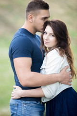 Cuddling young couple in park