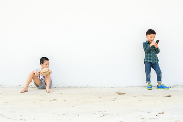 Young boy play smartphone compare with poor boy