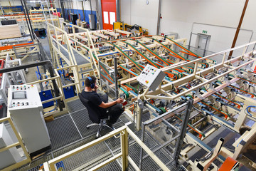 Arbeiter bedient Maschine im Sägewerk - automatisiertes hobeln von holzbrettern // woodworking -...