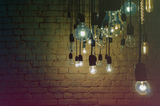 Incandescent lamps on a brick wall background.