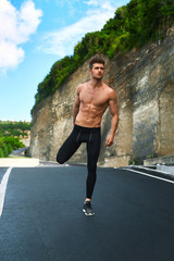 Fitness Exercise. Athletic Active Man With Fit Muscular Body Stretching, Exercising Before Running. Athlete Warming Up And Preparing For Workout. Male Runner Doing Stretches Outdoor. Sports Concept