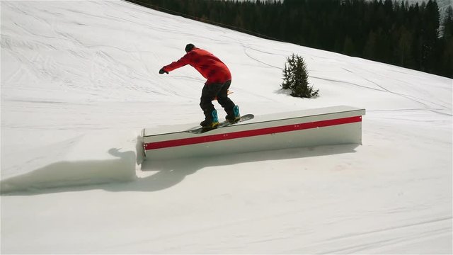 snowboard slow motion,snowboarder riding funbox doing board slide slow motion