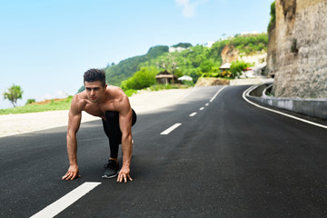 Sports. Healthy Athletic Man With Fit Muscular Body In Starting Position For Running On Road....