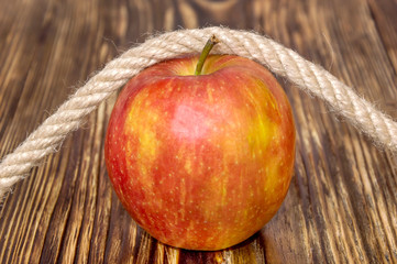 apple tied by rope to desk