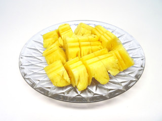 Diced pineapple fruit pieces on a glass plate