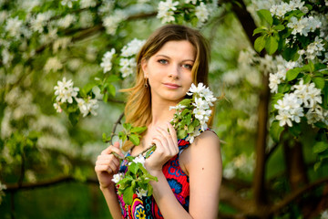fashion beautiful blonde woman in blossoming garden of Apple trees