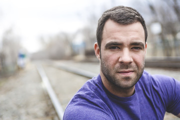 nice young man portrait on the railroad