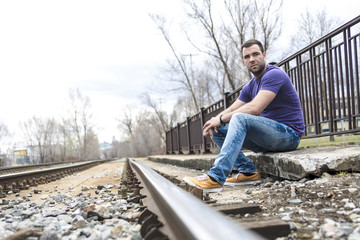 Fototapeta premium nice young man portrait on the railroad