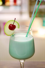 Glass of cocktail on bar background