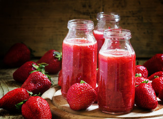 Strawberry smoothie in glass bottles, fresh berries, vintage woo